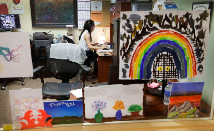art work from clients who have stayed at the acute treatment unit at axis health system decorates chrys valdez’s office window. valdez is the nurse manager with axis health system. (jerry mcbride/durango herald)